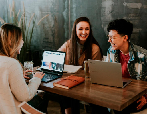 Xente rindo e empregando o ordenador
