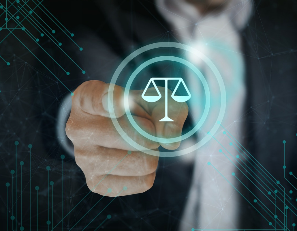 Mano señalando el icono de una balanza, símbolo de la justicia